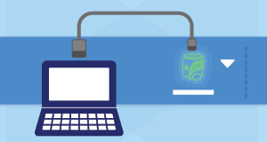 A laptop connected to a VEX AIM Coding Robot with a cable.